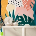 Tapeta ścienna z kolorowymi liśćmi tropikalnymi, wnętrze z jasną komodą i dekoracjami boho