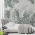 Elegancka sypialnia z szarym łóżkiem na tle ściany z fototapetą w tropikalne liście palmy i monstery w odcieniach szarości i szałwii