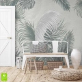 Jasny przedpokój w stylu boho z białą ławką i fototapetą w egzotyczne, szaro-zielone liście palmowe na ścianie